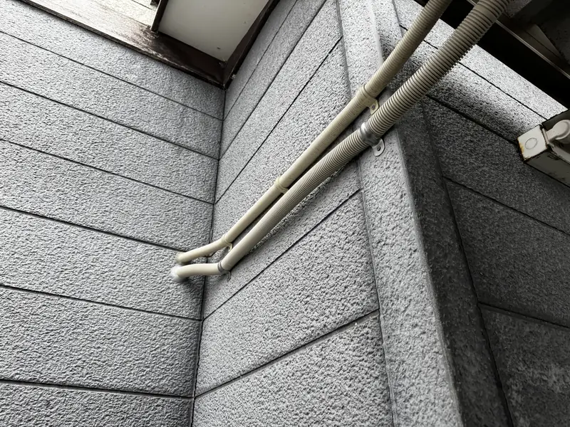 建物の外壁に沿ってPF管で保護された防犯カメラの配線